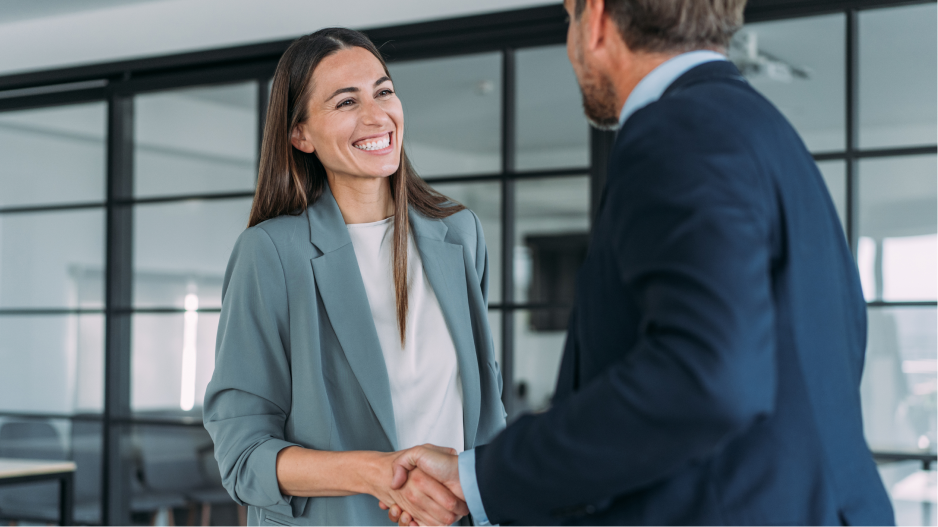 Two business people shake hands in an office.